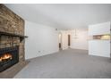 Spacious living room with a stone fireplace and adjacent dining area at 14171 E Jewell Ave # 203, Aurora, CO 80012