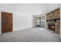 Cozy living room featuring a beautiful stone fireplace and sliding glass doors at 14171 E Jewell Ave # 203, Aurora, CO 80012