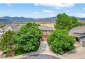 Scenic aerial view of home featuring mountain views and mature trees at 14682 W Amherst Pl, Lakewood, CO 80228