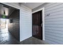 Exterior view of unit 107 featuring a black metal door and gray wood paneling at 7665 E Eastman Ave # 107B, Denver, CO 80231