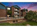 Brick apartment building with teal accents, balconies, and landscaped grounds at 2675 S Danube Way # 104, Aurora, CO 80013