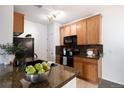 Modern kitchen featuring granite countertops and dark appliances at 2675 S Danube Way # 104, Aurora, CO 80013