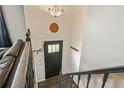 Welcoming entryway with dark wood door, staircase, and stylish light fixture at 8410 Gray St, Arvada, CO 80003