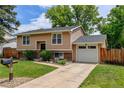 Inviting two-story house featuring an attached garage, green lawn, and tidy landscaping at 8410 Gray St, Arvada, CO 80003
