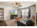 Cozy living room with a comfortable leather sofa, large TV, and a ceiling fan at 8410 Gray St, Arvada, CO 80003