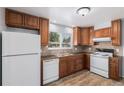Well-lit kitchen featuring wooden cabinets, stainless steel sink, and modern white appliances at 867 S Grape St, Denver, CO 80246