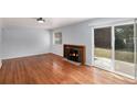 Bright living room featuring hardwood floors, a cozy fireplace, and sliding glass doors to the backyard at 867 S Grape St, Denver, CO 80246