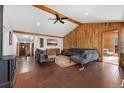 Spacious living room with wood-paneled accent wall, vaulted ceilings, and hardwood floors at 9998 W 70Th Pl, Arvada, CO 80004
