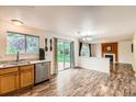Open dining room with wood floors, backyard access, and seamless flow to the living room at 1842 Reliance Cir, Superior, CO 80027