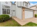 Attractive light gray home with brick accents and a two-car garage is complemented by a well-kept lawn and tidy landscaping at 1842 Reliance Cir, Superior, CO 80027