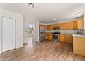 Open kitchen and dining area with stainless steel appliances, wood cabinets, and seamless access to the living area at 1842 Reliance Cir, Superior, CO 80027