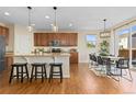 Bright kitchen featuring a large island, wooden cabinets, modern lighting, and an adjacent dining area at 381 Rainbow Ln, Lafayette, CO 80026