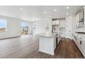 Modern, open concept kitchen with an island and stainless steel appliances at 9237 Truckee Ct, Commerce City, CO 80022