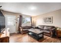 Cozy living room features hardwood floors, natural light, and comfortable leather sofas for relaxing or entertaining at 547 S 3Rd Avenue, Brighton, CO 80601