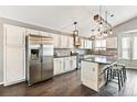 Modern kitchen boasts stainless steel appliances, white cabinetry, brick backsplash, and an island with bar seating at 5264 E 129Th Pl, Thornton, CO 80241