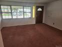 Bright living room featuring a decorative front door and large windows at 6961 E Arkansas Ave, Denver, CO 80224