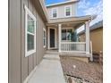Charming covered front porch with white columns and well maintained landscaping at 9021 Swan River St, Littleton, CO 80125