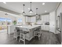 A chef's kitchen offers a large island with seating, stainless appliances, and ample counter space at 9021 Swan River St, Littleton, CO 80125