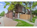 Charming townhome features a brick exterior with wooden accents, a well-maintained lawn, and mature trees at 9316 W Utah Ave, Lakewood, CO 80232