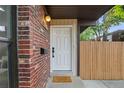 Inviting front door with brick accents, a stylish light fixture, and a neatly maintained walkway at 9316 W Utah Ave, Lakewood, CO 80232
