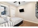 Cozy bedroom with a modern bed, hardwood floors, a window with curtains, and sleek, minimalist décor at 1565 W 67Th Ave, Denver, CO 80221