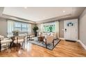Sun-drenched living room boasting hardwood floors, modern decor, and expansive windows overlooking the outdoors at 2692 N Raleigh St, Denver, CO 80212