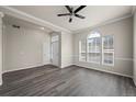 Inviting living room with arched window, modern ceiling fan, and stylish, dark-toned hardwood floors at 9856 Keenan St, Highlands Ranch, CO 80130