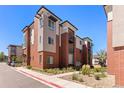 Stylish condo exterior with brick accents, balconies, and well-maintained landscaping at 14301 E Tennessee Ave # 109, Aurora, CO 80012