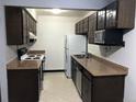 Functional kitchen featuring dark cabinets, tan countertops, and standard appliances at 16359 W 10Th Ave # 1, Golden, CO 80401