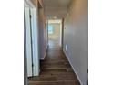 View of the hallway with wood floors, light-colored walls, and a view to another room at the end at 6046 Keyser Pl, Brighton, CO 80601