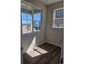 Bright room featuring wood floors and view of neighborhood through windows at 6046 Keyser Pl, Brighton, CO 80601
