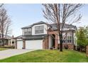 Charming two-story home with a well-manicured lawn and three car garage at 17705 W 63Rd Dr, Golden, CO 80403