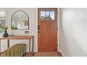 Cozy foyer featuring hardwood floors, a stylish mirror, and a charming wooden door, creating a warm entrance at 2830 Forest St, Denver, CO 80207