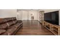 An inviting living room featuring hardwood floors and a comfortable leather couch at 2072 Skylark Ct, Longmont, CO 80503