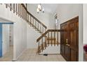 Grand foyer showcases staircase with wood railings and tiled floors adding a touch of elegance at 7659 S Rosemary Cir, Centennial, CO 80112