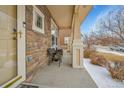 Cozy covered front porch with brick accents with a relaxing seating area to enjoy the outdoors at 23601 E Mississippi Cir, Aurora, CO 80018