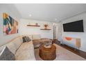 Cozy living room features hardwood floors, a sectional, and a mounted flatscreen television at 3753 N Cook St, Denver, CO 80205