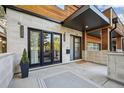 Modern stone and wood home exterior with a spacious front porch area and a contemporary outdoor rug at 445 Forest St, Denver, CO 80220