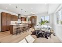 Open kitchen with island, stainless steel appliances, wood cabinets, and adjacent dining area at 960 Quitman St, Denver, CO 80204
