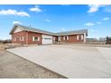Charming brick home featuring a well-kept driveway, and an attached garage, showcasing great curb appeal at 23753 E 155Th Way, Brighton, CO 80603