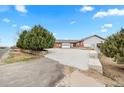 Spacious home featuring a wide driveway leading to an attached garage, complemented by mature trees for added privacy at 23753 E 155Th Way, Brighton, CO 80603