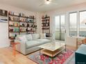 Bright living room features hardwood floors, comfortable seating, floor to ceiling bookshelves, and balcony access at 3701 Arapahoe Ave # 304, Boulder, CO 80303