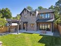 Beautiful backyard featuring a stone patio, built-in grill, pergola, and lush lawn, perfect for outdoor entertaining at 2511 S Columbine St, Denver, CO 80210