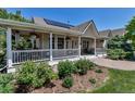 Inviting porch features a cozy seating area, hanging plants, and charming curb appeal at 6633 E 166Th Pl, Brighton, CO 80602