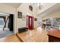 Bright foyer with high ceilings, hardwood floors, red door, and elegant chandelier at 8389 Owl Roost Ct, Parker, CO 80134