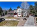 Charming two-story home with a brick facade, covered porch, and well-maintained front yard at 8389 Owl Roost Ct, Parker, CO 80134