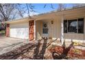Inviting front porch with brick accents, leading to a well-lit entryway. A welcoming floral wreath adorns the front door at 2165 S Nucla Way, Aurora, CO 80013