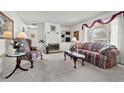 Bright and airy living room featuring a cozy fireplace, plush seating, and a large window with natural light at 2165 S Nucla Way, Aurora, CO 80013
