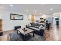 Open living space showing a dark leather sofa and a white kitchen with stainless steel appliances at 2286 S Pitkin Way # A, Aurora, CO 80013