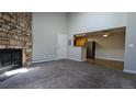 The living room features carpet, a stone fireplace, and a view to the kitchen with modern appliances at 10150 E Virginia Ave # 308, Denver, CO 80247